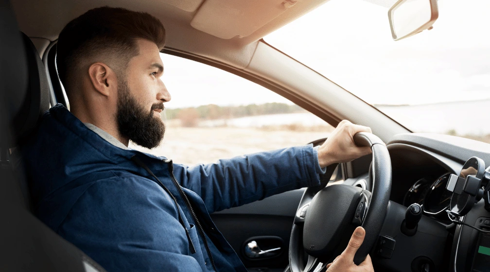 Imagem de homem jovem dirigindo para ilustrar o artigo sobre "passei no pedágio e não paguei o que fazer"