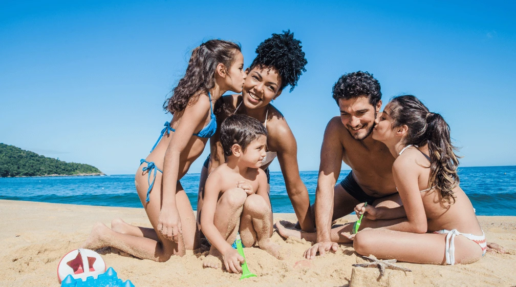 Foto de família se divertindo na praia para ilustrar o artigo sobre pedágio Praia Grande.