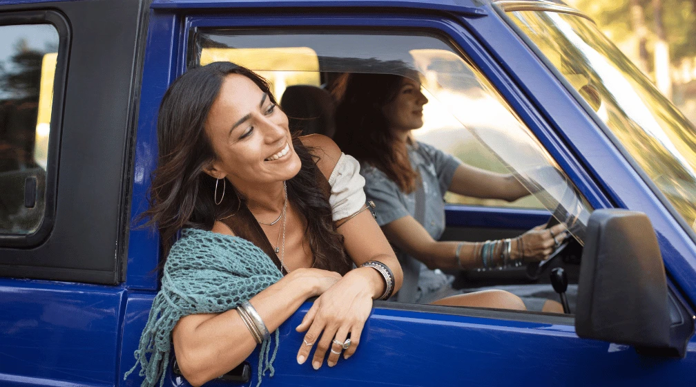 Duas jovens sorridentes em uma viagem de carro